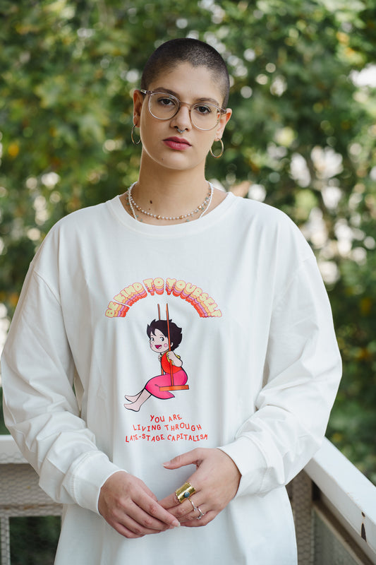 Person wearing a white sweatshirt with a graphic design outdoors