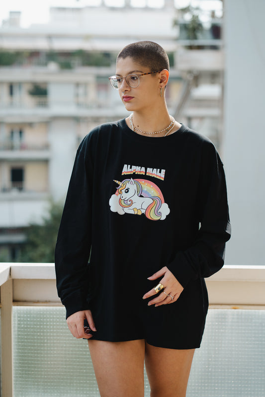 Person wearing a black sweatshirt with a unicorn graphic and text, standing outdoors.