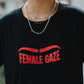 Person wearing a black t-shirt with 'FEMALE GAZE' in red text.
