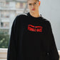 Person wearing a black sweatshirt with 'FEMALE GAZE' text, standing outdoors.
