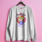 White sweatshirt with a graphic design and text on a pink background