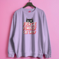 lilac sweatshirt with 'Fierce Feminist Cat Lady' text and cat graphic on a pink background
