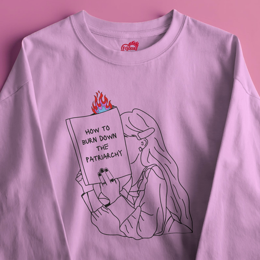pink sweatshirt with a graphic design of a person holding a book titled 'How to Burn Down the Patriarchy' on a pink background.