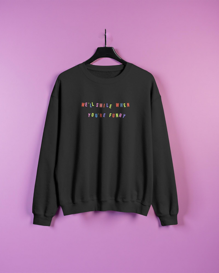 Black sweatshirt with colorful text on a pink background
