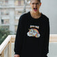Person wearing a black sweatshirt with a colorful unicorn graphic and text, standing outdoors.