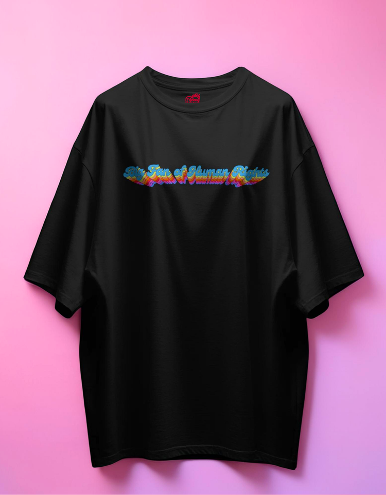 Black t-shirt with colorful graphic design on a pink background