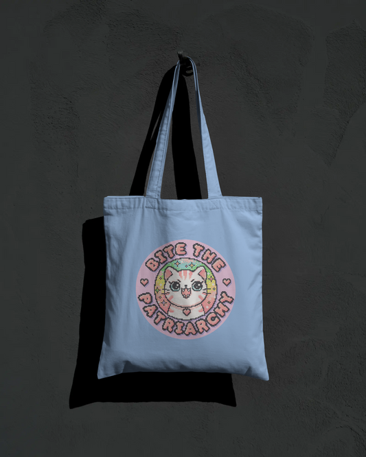 Light blue tote bag with a cat graphic and text on a dark background