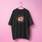 black t-shirt with a graphic design on a pink background