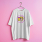 White t-shirt with a graphic design on a pink background